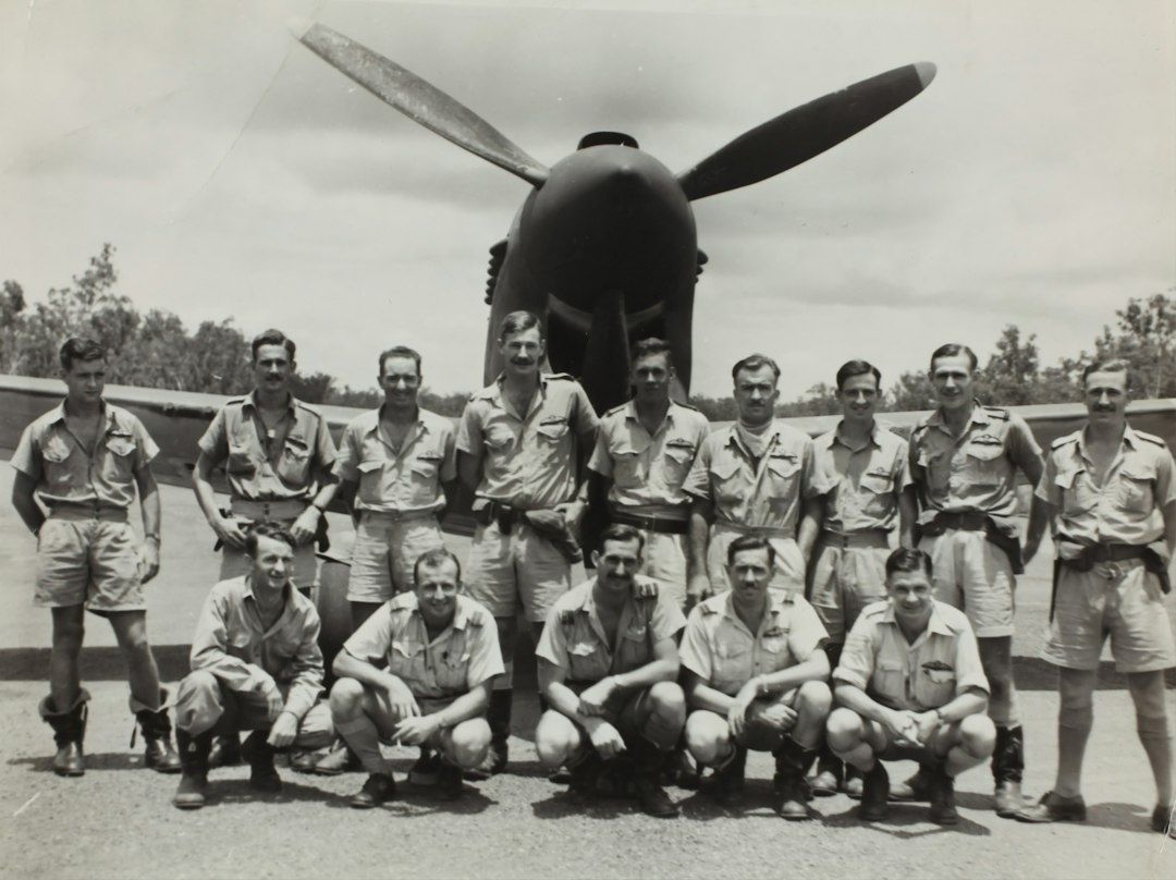 Gruppbild av flygpersonal framför ett propellerflygplan
